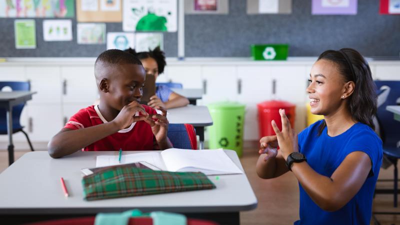 Classroom. Teacher and boy communicatie through sign language